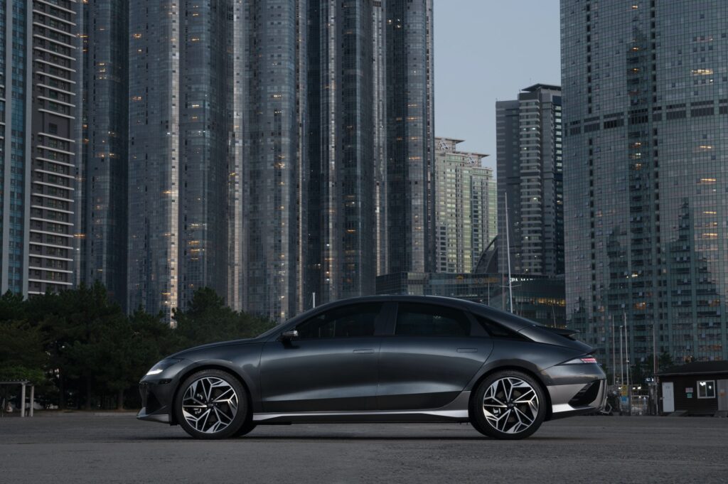 Fancy grey ev car with ev tyres in front of buildings