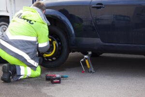 A person putting a spare tyre on