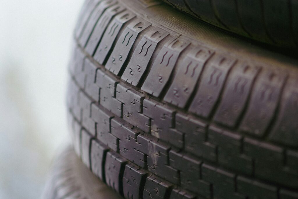 lose-up of stacked used tyres showing worn tread patterns and age indicators.