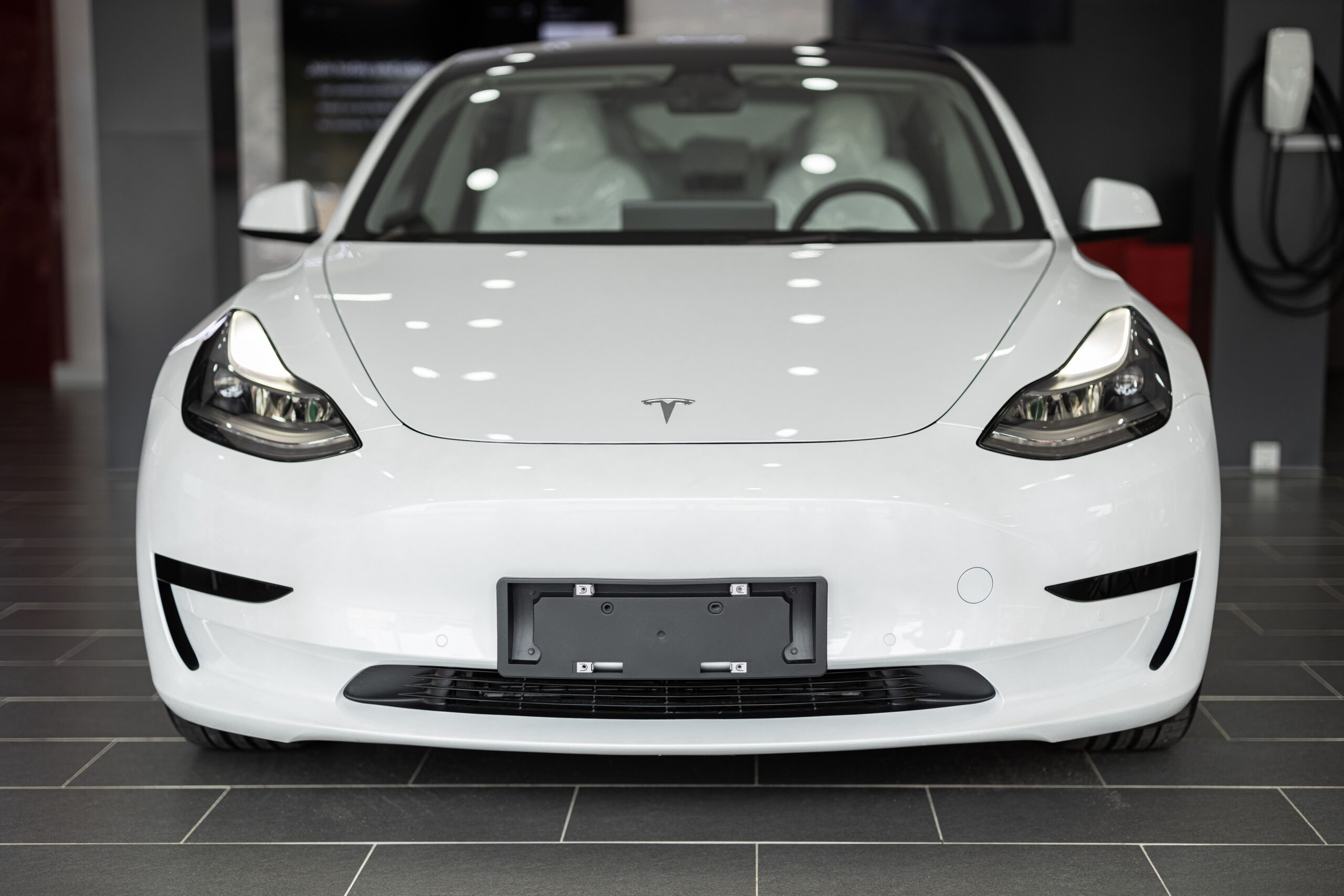 Front view of a white Tesla in a showroom